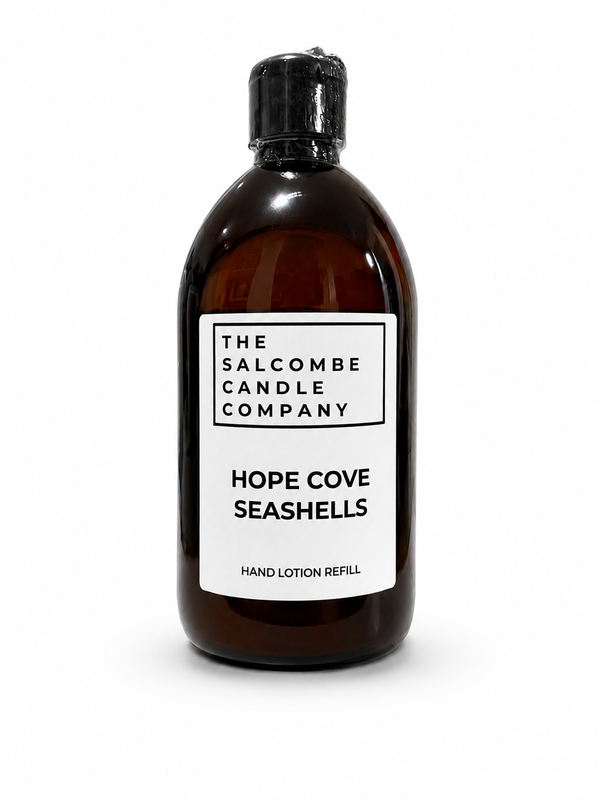 An amber PET bottle with a black cap and a white label reading 'THE SALCOMBE CANDLE COMPANY' and 'HOPE COVE SEASHELLS HAND LOTION REFILL', photographed on a white background.