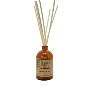 Reed diffuser with ratten reeds in an amber bottle labeled 'The Salcombe Candle Company' on a white background.